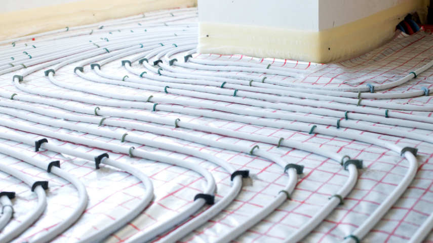 Installation de plancher chauffant avec tubes PER fixés sur isolant avant coulage de la chape